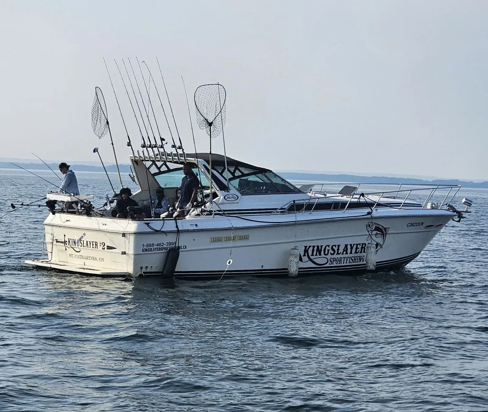 Kingslayer #2, one of the two 42-foot Sea-Rays, idling near shore with four crew aboard and the rod rack up