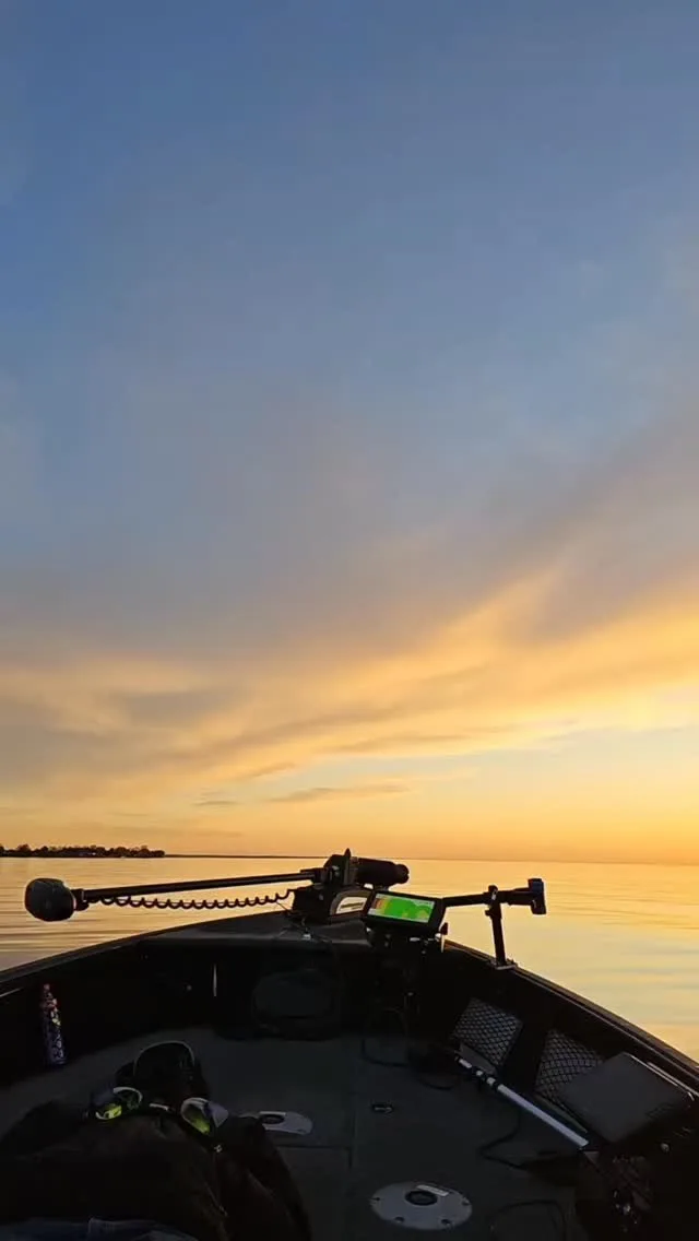 Sunset view from the bow of the boat over calm water