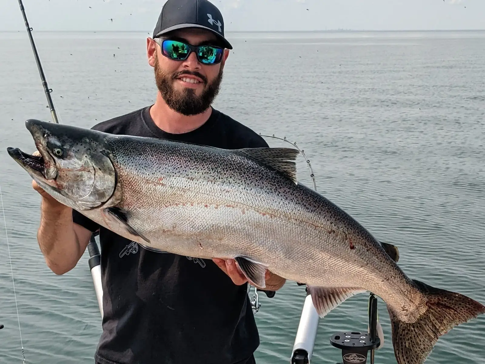 Captain Connor Ivanchuk holding a chinook salmon on Lake Ontario