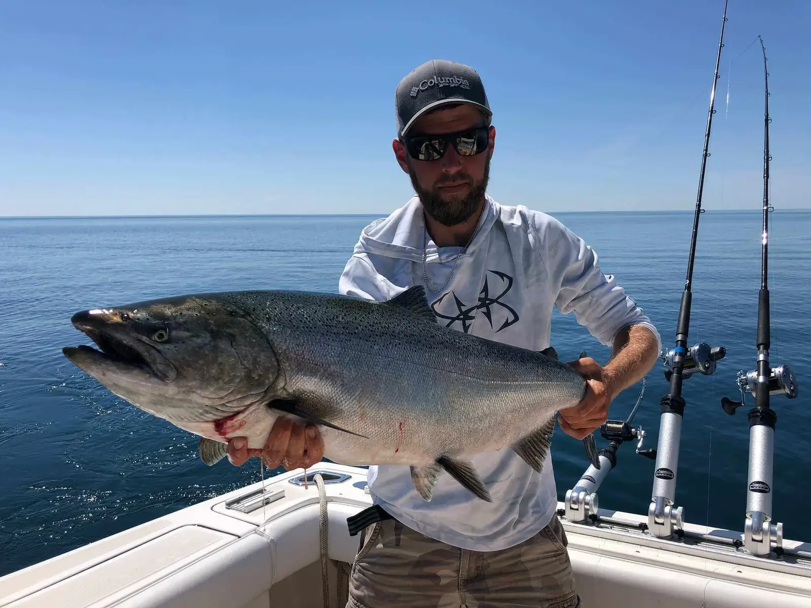 Captain Lucas Dracz holding a chinook salmon on Lake Ontario