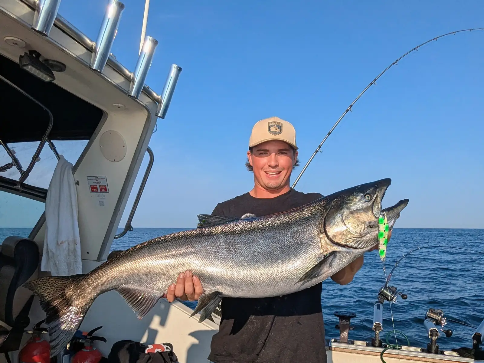 Angler holding a large chinook salmon aboard a King Slayer Sea-Ray on Lake Ontario