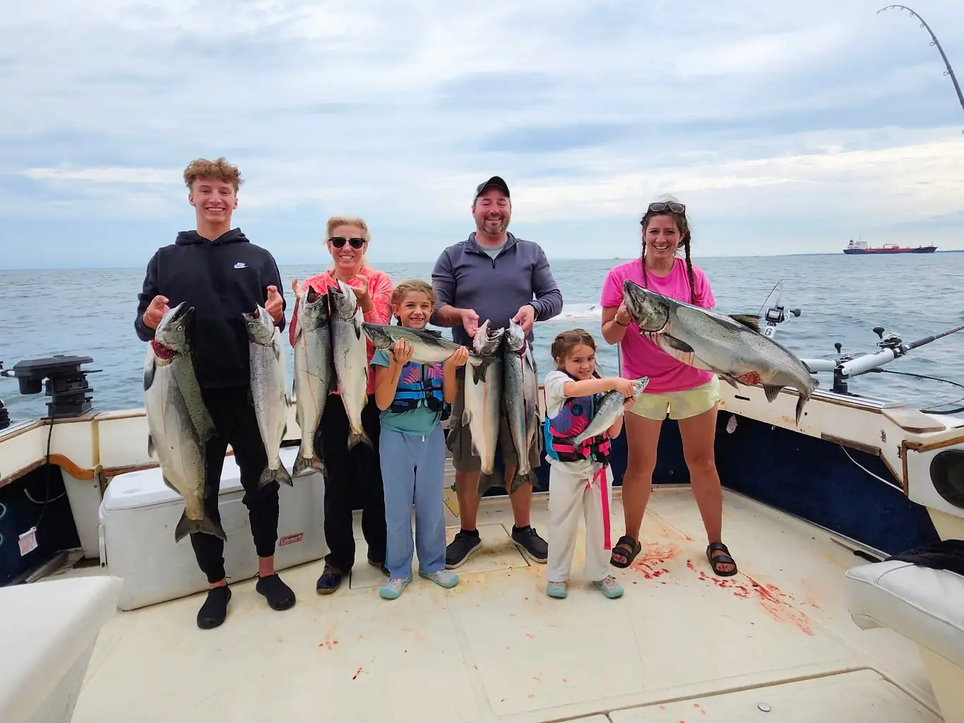 A family of six on deck holding the salmon they caught on a King Slayer charter