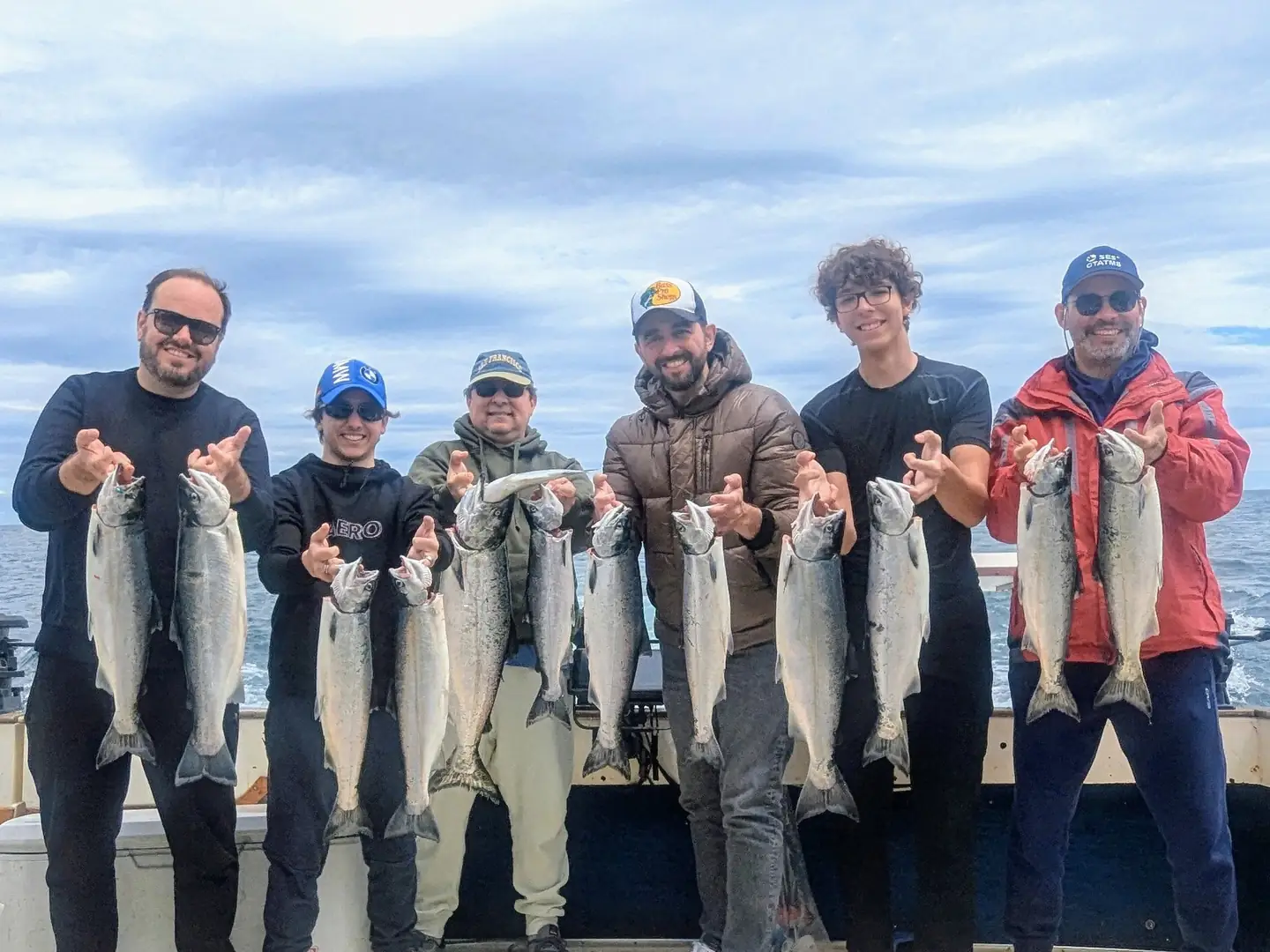 A group of six guests holding a full limit of salmon after a Lake Ontario trip