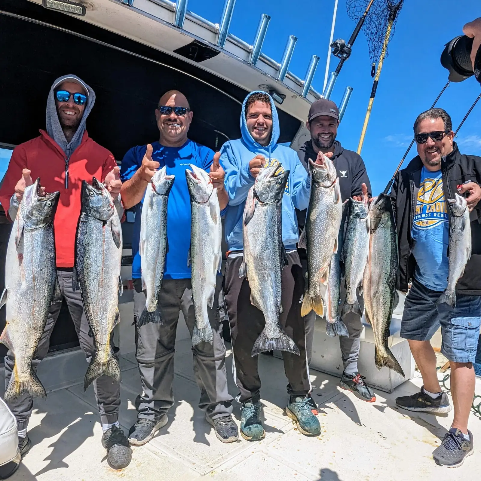 Five smiling anglers giving a thumbs up with their Lake Ontario chinook salmon